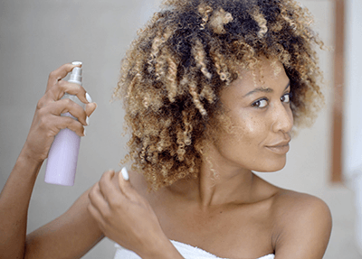 Femme appliquant un shampoing sec