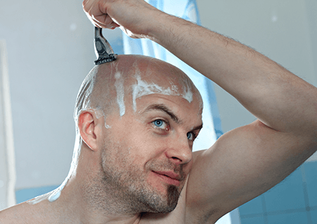 Un homme se rasant la tête - A Un Cheveu